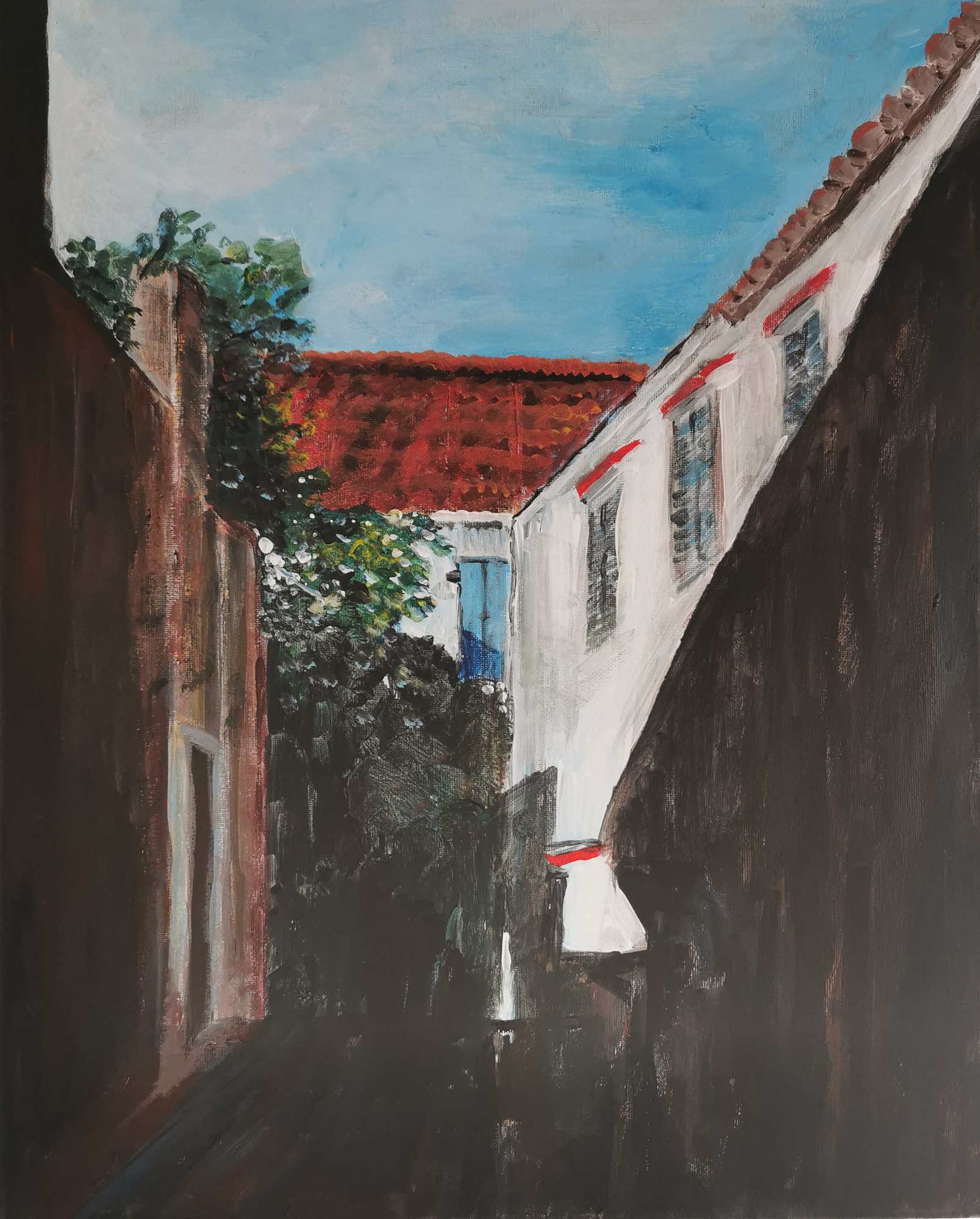 Slika uskog seoskog prolaza između bijelog i tamnog zida pod plavim nebom.